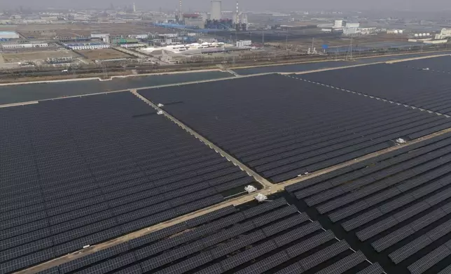 FILE - A solar farm operates near a chemical plant on the outskirts of Weifang in eastern China's Shandong province on March 22, 2024. (AP Photo/Ng Han Guan, File)