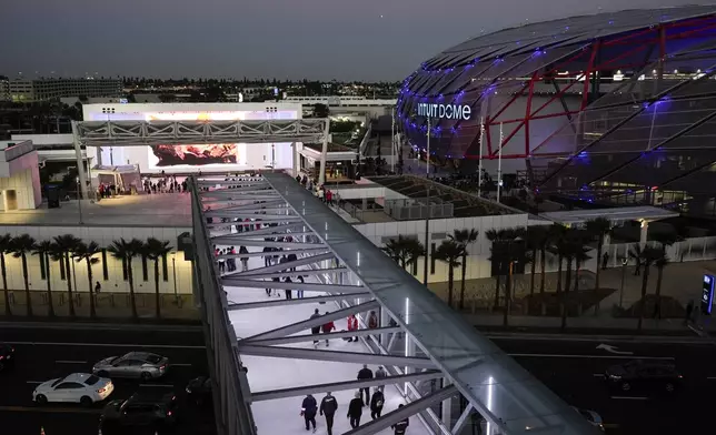 Fans walk on a bridge to the Intuit Dome, the new home of the Los Angeles Clippers, before the team's NBA preseason basketball game against the Dallas Mavericks Monday, Oct. 14, 2024, in Inglewood, Calif.(AP Photo/Jae C. Hong)