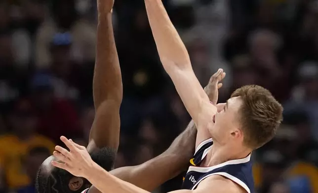 Denver Nuggets guard Christian Braun (0) blocks a shot by Los Angeles Clippers guard James Harden (1) during the first half of an NBA basketball game Saturday, Oct. 26, 2024, in Denver. (AP Photo/Jack Dempsey)