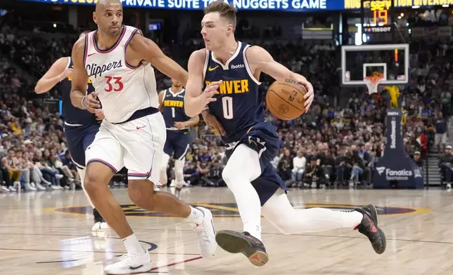 Denver Nuggets guard Christian Braun (0) drives to the basket past Los Angeles Clippers forward Nicolas Batum (33) during the first half of an NBA basketball game Saturday, Oct. 26, 2024, in Denver. (AP Photo/Jack Dempsey)