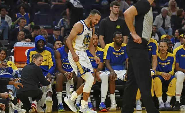 Golden State Warriors' Stephen Curry, center, yells after sustaining an injury to his left ankle in the fourth quarter of an NBA basketball game against the Los Angeles Clippers in San Francisco, Sunday, Oct. 27, 2024. (Jose Carlos Fajardo/Bay Area News Group via AP)