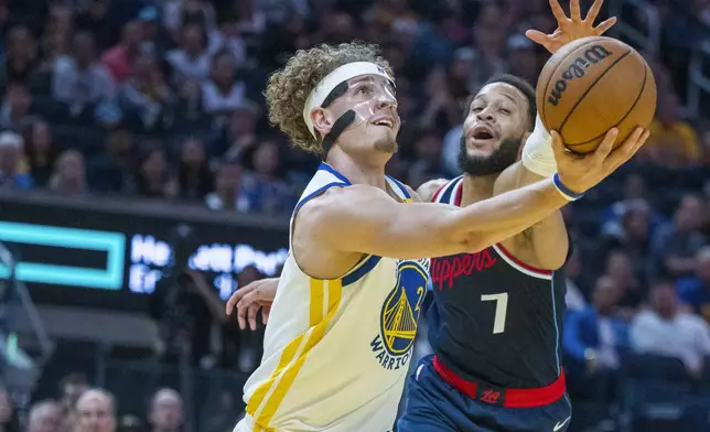 Golden State Warriors guard Brandin Podziemski (2) lays up a basket over Los Angeles Clippers guard Amir Coffey (7) during the first half of an NBA basketball game in San Francisco, Sunday, Oct. 27, 2024. (AP Photo/Nic Coury)