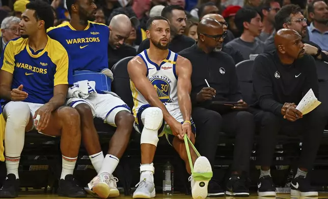 Golden State Warriors' Stephen Curry (30) stretches his left ankle after sustaining an injury in the third quarter of an NBA basketball game against the Los Angeles Clippers in San Francisco, Sunday, Oct. 27, 2024. (Jose Carlos Fajardo/Bay Area News Group via AP)