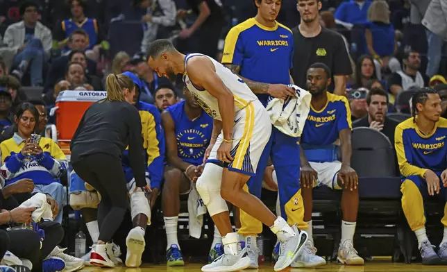 Golden State Warriors' Stephen Curry, center front, hobbles off the court after sustaining an injury to his left ankle in the fourth quarter of an NBA basketball game against the Los Angeles Clippers in San Francisco, Sunday, Oct. 27, 2024. (Jose Carlos Fajardo/Bay Area News Group via AP)