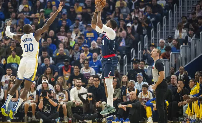 Los Angeles Clippers guard Norman Powell (24) shoots over Golden State Warriors forward Jonathan Kuminga (00) during the first half of an NBA basketball game in San Francisco, Sunday, Oct. 27, 2024. (AP Photo/Nic Coury)