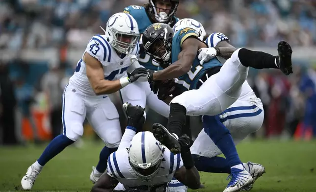 Jacksonville Jaguars tight end Brenton Strange (85) is tackled by Indianapolis Colts' Drew Ogletree (85) during the first half of an NFL football game, Sunday, Oct. 6, 2024, in Jacksonville, Fla. (AP Photo/Phelan M. Ebenhack)