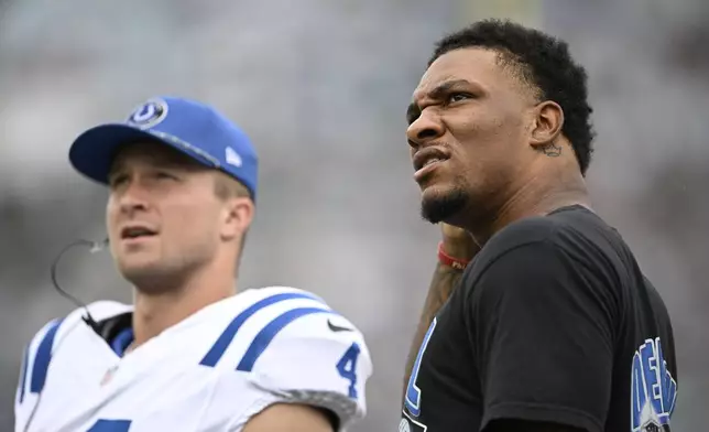 Indianapolis Colts quarterback Anthony Richardson, right, watches during the first half of an NFL football game against the Jacksonville Jaguars, Sunday, Oct. 6, 2024, in Jacksonville, Fla. (AP Photo/Phelan M. Ebenhack)