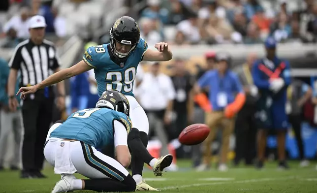 Jacksonville Jaguars place kicker Cam Little (39) kicks a field goal out of the hole of Logan Cooke during the first half of an NFL football game against the Indianapolis Colts, Sunday, Oct. 6, 2024, in Jacksonville, Fla. (AP Photo/Phelan M. Ebenhack)