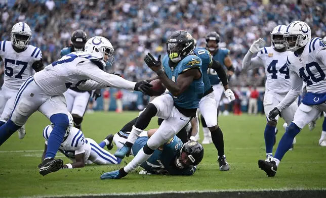 Jacksonville Jaguars running back Tank Bigsby (4) goes in for a touchdown during the second half of an NFL football game against the Indianapolis Colts, Sunday, Oct. 6, 2024, in Jacksonville, Fla. (AP Photo/Phelan M. Ebenhack)