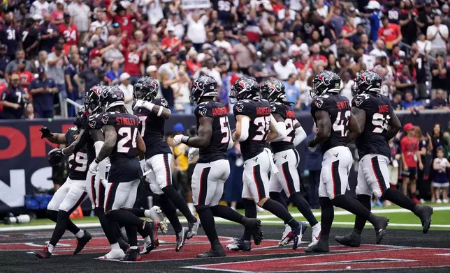 Houston Texans defenders celebrate after an interception by safety Jalen Pitre during the first half of an NFL football game against the Indianapolis Colts, Sunday, Oct. 27, 2024, in Houston. (AP Photo/Tony Gutierrez)