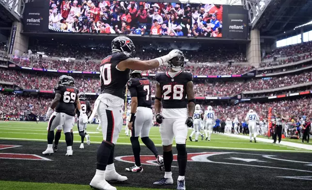 Houston Texans running back Joe Mixon (28) celebrates with teammate Juice Scruggs (70) after a 14-yard touchdown run during the first half of an NFL football game against the Indianapolis Colts, Sunday, Oct. 27, 2024, in Houston. (AP Photo/Tony Gutierrez)