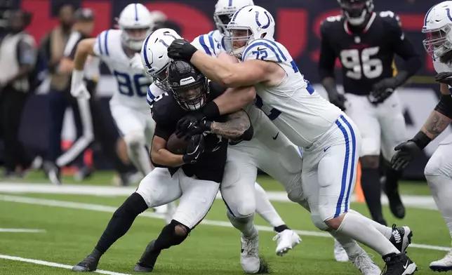 Houston Texans safety Jalen Pitre (5) is tackled by Indianapolis Colts offensive tackle Braden Smith (72) after intercepting a pass during the first half of an NFL football game, Sunday, Oct. 27, 2024, in Houston. (AP Photo/Eric Christian Smith)