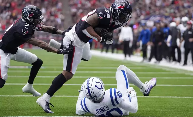 Houston Texans running back Joe Mixon (28) runs over Indianapolis Colts cornerback Jaylon Jones (40) during a 14-yard touchdown run in the first half of an NFL football game, Sunday, Oct. 27, 2024, in Houston. (AP Photo/Tony Gutierrez)