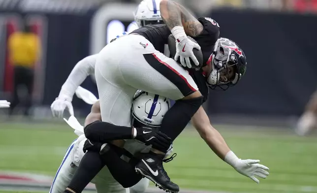 Houston Texans tight end Cade Stover, right, is tackled by Indianapolis Colts linebacker E.J. Speed during the first half of an NFL football game, Sunday, Oct. 27, 2024, in Houston. (AP Photo/Eric Christian Smith)