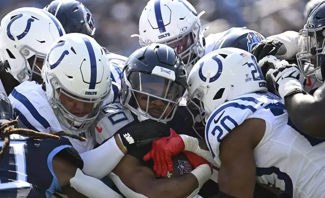 Tennessee Titans running back Tony Pollard (20) is stopped by the Indianapolis Colts during the second half of an NFL football game, Sunday, Oct. 13, 2024, in Nashville, Tenn. (AP Photo/John Amis)