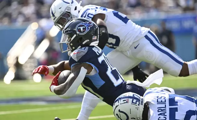 Tennessee Titans running back Tony Pollard (20) is tackled byIndianapolis Colts' Jaylon Carlies (57) during the first half of an NFL football game, Sunday, Oct. 13, 2024, in Nashville, Tenn. (AP Photo/John Amis)