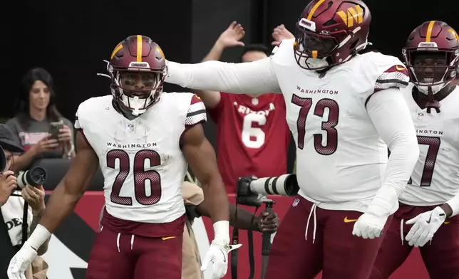 Washington Commanders running back Jeremy McNichols (26) celebrates his touchdown with offensive tackle Trent Scott (73) during the first half of an NFL football game against the Arizona Cardinals, Sunday, Sept. 29, 2024, in Glendale, Ariz. (AP Photo/Rick Scuteri)