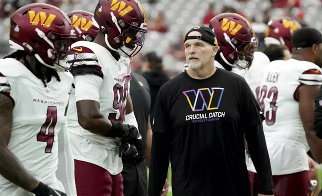 Washington Commanders head coach Dan Quinn talks to his players prior to an NFL football game against the Arizona Cardinals, Sunday, Sept. 29, 2024, in Glendale, Ariz. (AP Photo/Rick Scuteri)