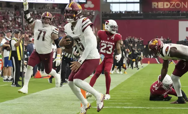 Washington Commanders quarterback Jayden Daniels (5) runs for a touchdown as Arizona Cardinals safety Jalen Thompson (34) defends during the second half of an NFL football game, Sunday, Sept. 29, 2024, in Glendale, Ariz. (AP Photo/Rick Scuteri)