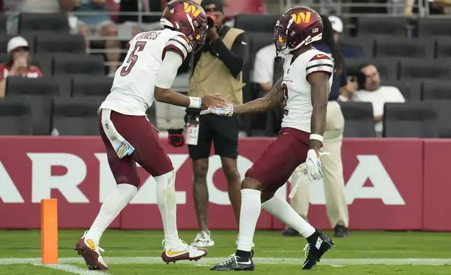 Washington Commanders quarterback Jayden Daniels (5) celebrates his touchdown run against the Arizona Cardinals during the second half of an NFL football game, Sunday, Sept. 29, 2024, in Glendale, Ariz. (AP Photo/Ross D. Franklin)