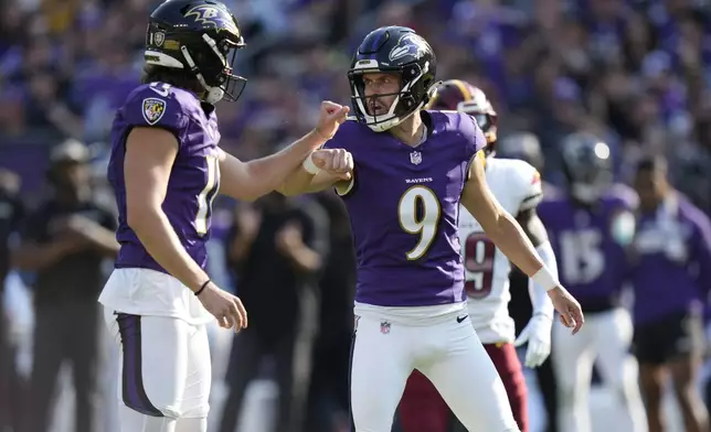 Baltimore Ravens kicker Justin Tucker (9) is congratulated by Jordan Stout after making a 39-yard field goal during the second half of an NFL football game against the Washington Commanders Sunday, Oct. 13, 2024, in Baltimore. (AP Photo/Stephanie Scarbrough)