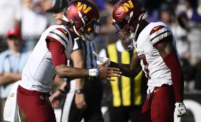 Washington Commanders wide receiver Terry McLaurin, right, is congratulated by quarterback Jayden Daniels after catching a 6-yard touchdown pass during the second half of an NFL football game against the Baltimore Ravens Sunday, Oct. 13, 2024, in Baltimore. (AP Photo/Nick Wass)