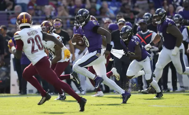 Baltimore Ravens quarterback Lamar Jackson (8) runs for a 33-yard gain as Washington Commanders safety Quan Martin (20) defends during the second half of an NFL football game Sunday, Oct. 13, 2024, in Baltimore. (AP Photo/Stephanie Scarbrough)