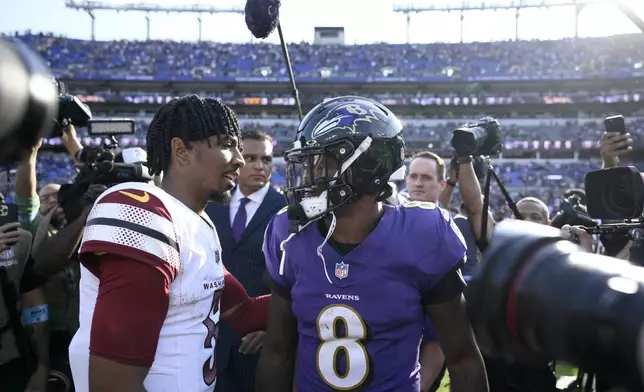 Washington Commanders quarterback Jayden Daniels, left, talks with Baltimore Ravens quarterback Lamar Jackson following an NFL football game Sunday, Oct. 13, 2024, in Baltimore. The Ravens won 30-23. (AP Photo/Nick Wass)