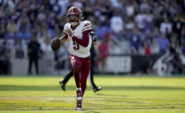 Washington Commanders quarterback Jayden Daniels scrambles during the second half of an NFL football game against the Baltimore Ravens Sunday, Oct. 13, 2024, in Baltimore. (AP Photo/Stephanie Scarbrough)