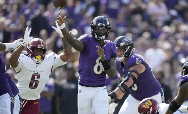 Baltimore Ravens quarterback Lamar Jackson (8) throws as Washington Commanders linebacker Dante Fowler Jr (6) defends during the first half of an NFL football game against the Washington Commanders Sunday, Oct. 13, 2024, in Baltimore. (AP Photo/Stephanie Scarbrough)