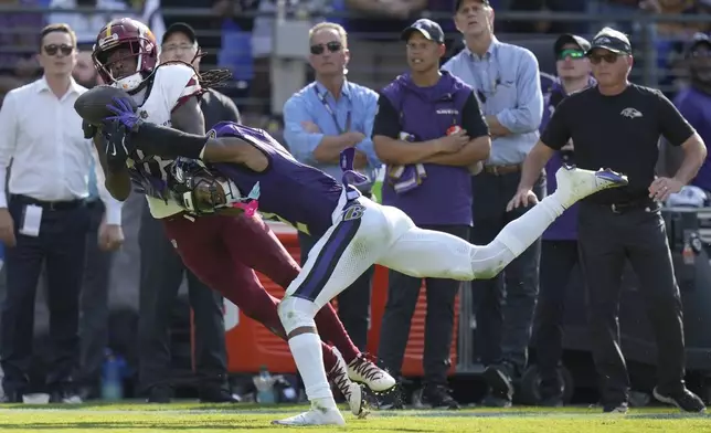 Washington Commanders wide receiver Noah Brown is unable to catch a pass as Baltimore Ravens cornerback Nate Wiggins, right, commits pass interference during the second half of an NFL football game Sunday, Oct. 13, 2024, in Baltimore. (AP Photo/Stephanie Scarbrough)