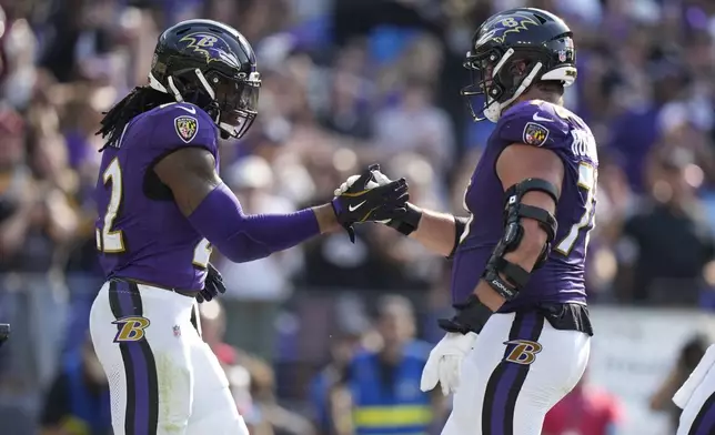 Baltimore Ravens running back Derrick Henry, left, is congratulated by Roger Rosengarten after scoring on a 7-yard run during the second half of an NFL football game against the Washington Commanders Sunday, Oct. 13, 2024, in Baltimore. (AP Photo/Stephanie Scarbrough)