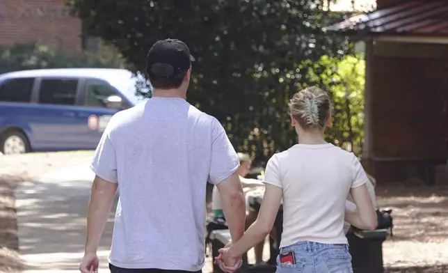 A couple holds hands at the University of Mississippi campus in Oxford, Miss., Wednesday, Aug. 28, 2024. (AP Photo/Karen Pulfer Focht)