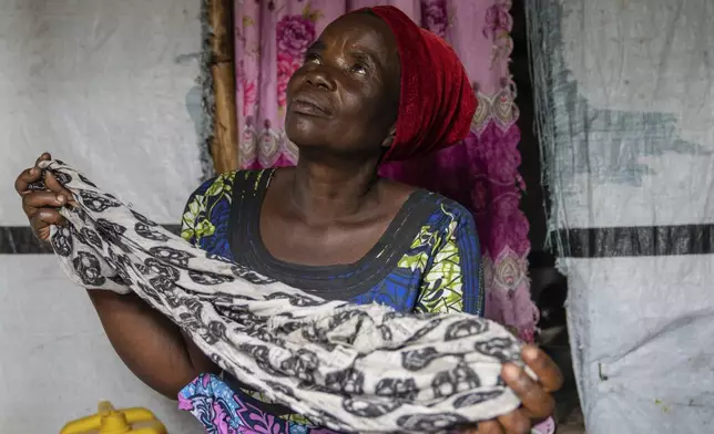 Nelly Shukuru, 51, hold the scarf she had planned on using to hang herself after spending three years displaced in the Lushagala camp in Goma, Democratic Republic of the Congo, Tuesday, Aug. 27, 2024. (AP Photo/Moses Sawasawa)