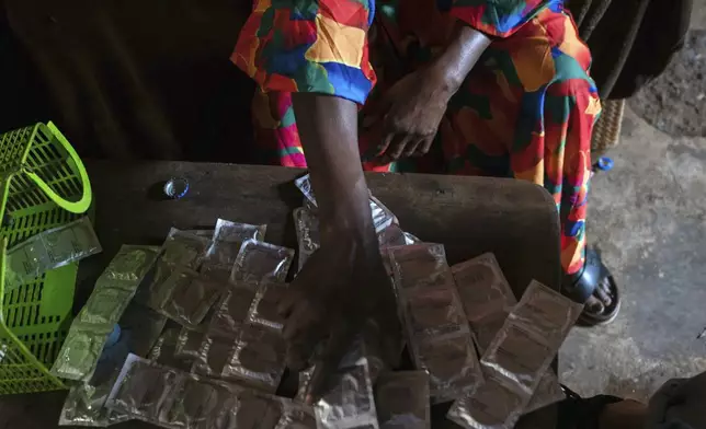 Sifa Kunguja, a 40-year-old sex worker, sorts through condoms at home after recovering from mpox Wednesday, Sept. 4, 2024 in Kamituga, eastern Congo. (AP Photo/Moses Sawasawa)