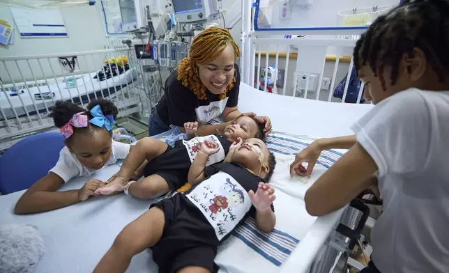 This undated photo provided by the Children’s Hospital of Philadelphia shows previously conjoined twins, Amari and Javar Ruffin, surrounded by family after separation surgery at the Children’s Hospital of Philadelphia. (Ed Cunicelli/Children’s Hospital of Philadelphia via AP)