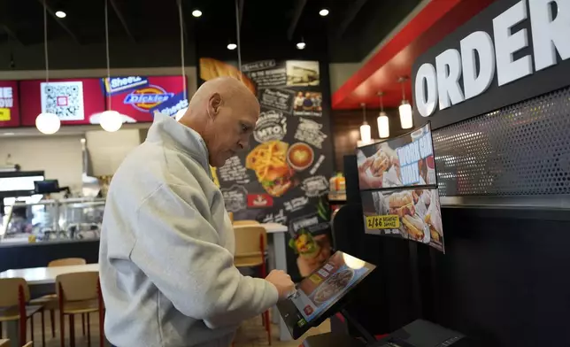 Brian Blair, of Akron, Ohio, enters his food order at a Sheetz convenience store, Thursday, Oct. 17, 2024, in Bethlehem, Pa. (AP Photo/Matt Slocum)