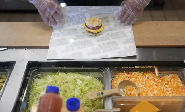 Sheetz employee Dylan Sachs prepares a breakfast sandwich at the convenience store, Thursday, Oct. 17, 2024, in Bethlehem, Pa. (AP Photo/Matt Slocum)