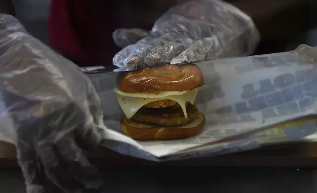 A Sheetz employee prepares a breakfast sandwich at the convenience store, Thursday, Oct. 17, 2024, in Bethlehem, Pa. (AP Photo/Matt Slocum)