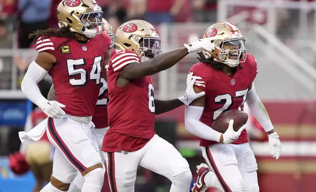 San Francisco 49ers safety Ji'Ayir Brown (27) celebrates with linebacker Fred Warner (54) and safety Malik Mustapha (6) after intercepting a pass against the Dallas Cowboys during the first half of an NFL football game in Santa Clara, Calif., Sunday, Oct. 27, 2024. (AP Photo/Tony Avelar)