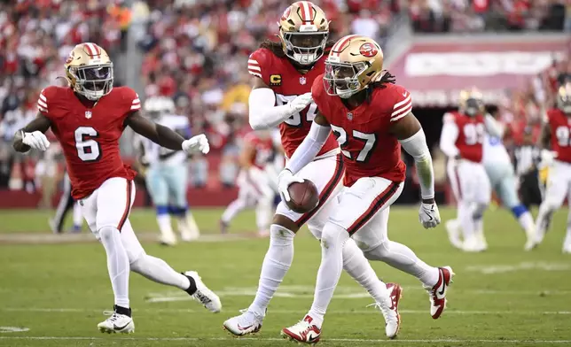 San Francisco 49ers safety Ji'Ayir Brown (27) celebrates with linebacker Fred Warner, middle, and safety Malik Mustapha (6) after intercepting a pass against the Dallas Cowboys during the first half of an NFL football game in Santa Clara, Calif., Sunday, Oct. 27, 2024. (AP Photo/Eakin Howard)