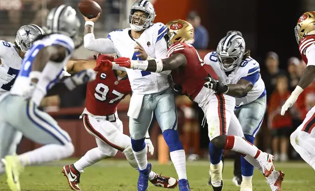 Dallas Cowboys quarterback Dak Prescott, middle, is hit by San Francisco 49ers defensive tackle Sam Okuayinonu during the first half of an NFL football game in Santa Clara, Calif., Sunday, Oct. 27, 2024. (AP Photo/Eakin Howard)