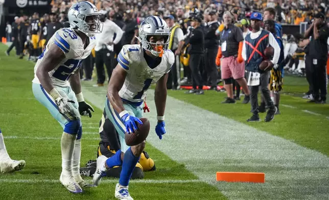 Dallas Cowboys wide receiver Jalen Tolbert (1) celebrates his touchdown catch with running back Rico Dowdle (23) during the second half of an NFL football game against the Pittsburgh Steelers, early Monday, Oct. 7, 2024, in Pittsburgh. The Cowboys won 20-17. (AP Photo/Gene J. Puskar)