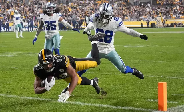 Pittsburgh Steelers tight end Connor Heyward (83) dives in for a touchdown after making a catch in front of Dallas Cowboys safety Malik Hooker (28) and linebacker Marist Liufau (35) during the second half of an NFL football game, Sunday, Oct. 6, 2024, in Pittsburgh. (AP Photo/Gene J. Puskar)