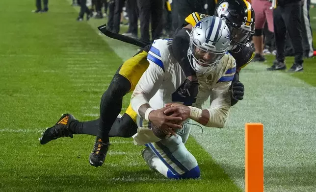 Dallas Cowboys quarterback Dak Prescott, front, is stopped short of the goal line by Pittsburgh Steelers safety Minkah Fitzpatrick during the second half of an NFL football game, early Monday, Oct. 7, 2024, in Pittsburgh. The Cowboys won 20-17. (AP Photo/Gene J. Puskar)