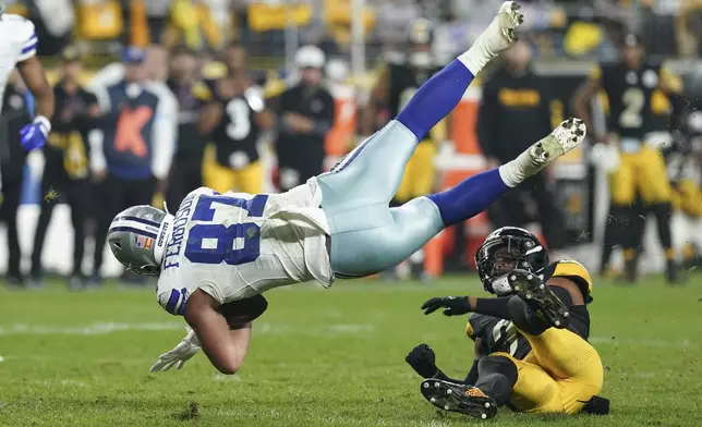 Dallas Cowboys tight end Jake Ferguson (87) is tripped by Pittsburgh Steelers safety Minkah Fitzpatrick during the second half of an NFL football game, Sunday, Oct. 6, 2024, in Pittsburgh. (AP Photo/Matt Freed)