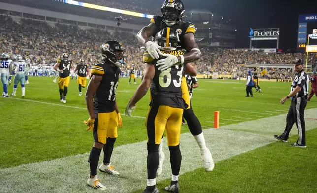 Pittsburgh Steelers tight end Connor Heyward (83) celebrates his touchdown catch with wide receiver Calvin Austin III (19) and tight end Darnell Washington, top, during the second half of an NFL football game against the Dallas Cowboys, Sunday, Oct. 6, 2024, in Pittsburgh. (AP Photo/Gene J. Puskar)