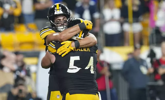 Pittsburgh Steelers tight end Pat Freiermuth, top, reacts with center Zach Frazier after scoring on a touchdown catch against the Dallas Cowboys during the second half of an NFL football game, early Monday, Oct. 7, 2024, in Pittsburgh. (AP Photo/Matt Freed)