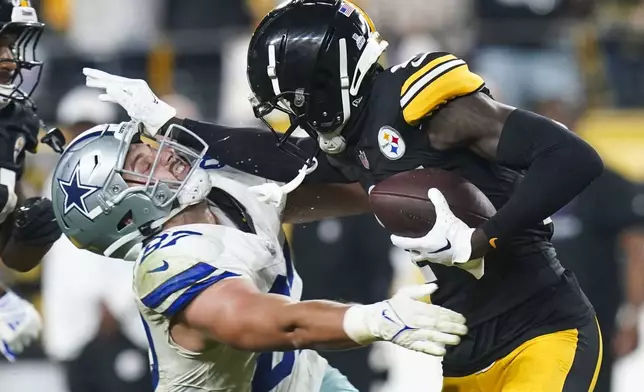 Pittsburgh Steelers cornerback Joey Porter Jr., right, puts a stiff arm on Dallas Cowboys tight end Jake Ferguson after making an interception during the second half of an NFL football game, early Monday, Oct. 7, 2024, in Pittsburgh. The Cowboys won 20-17. (AP Photo/Matt Freed)