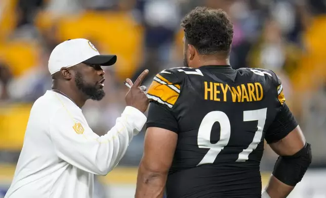 Pittsburgh Steelers head coach Mike Tomlin, left, talks to defensive tackle Cameron Heyward (97) prior to an NFL football game against the Dallas Cowboys, Sunday, Oct. 6, 2024, in Pittsburgh. (AP Photo/Gene J. Puskar)